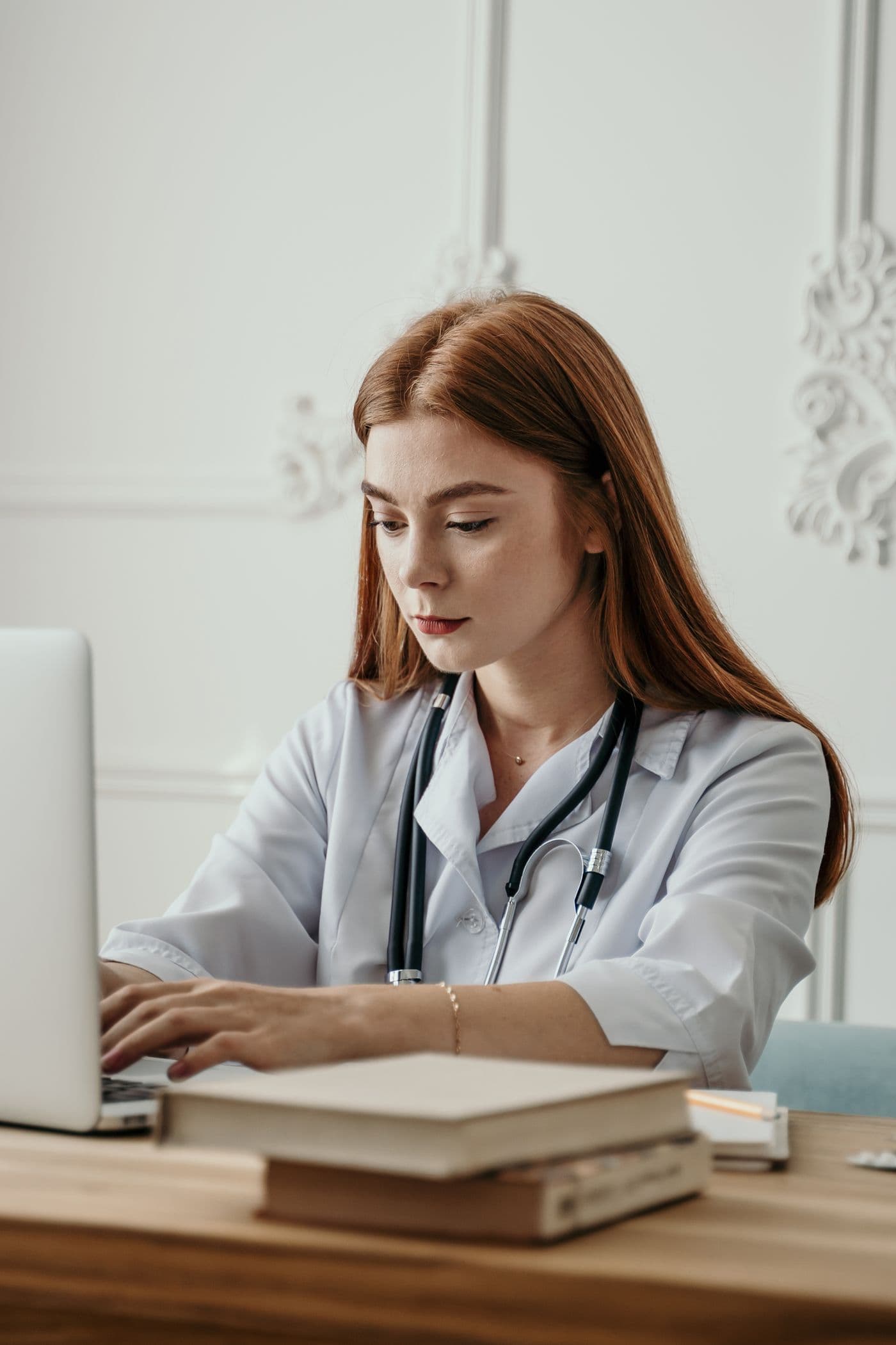 Dokter perempuan menggunakan laptop untuk mengelola klinik secara digital