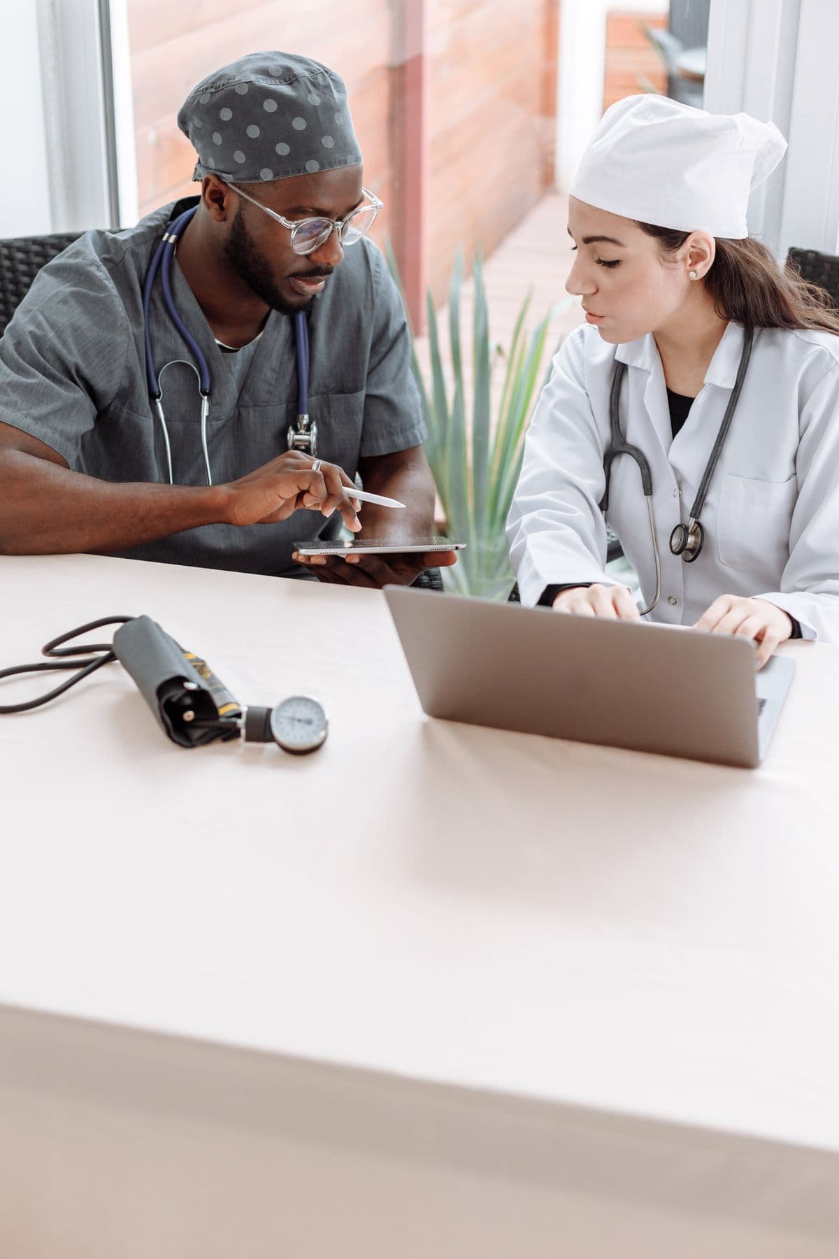 Tim tenaga medis menggunakan tablet dan laptop untuk mencoba sistem informasi klinik Medhop
